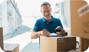 Photo of a man signing paperwork for a received delivery
